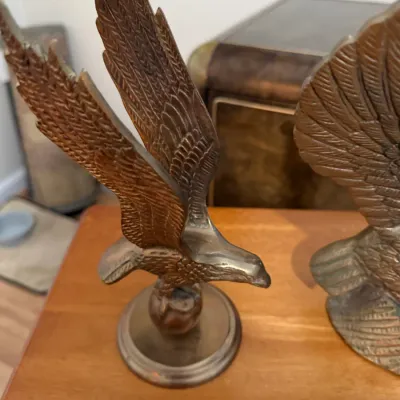 Sale Photo Thumbnail #364: Vintage solid brass eagle figurine depicted in flight on a round pedestal base.