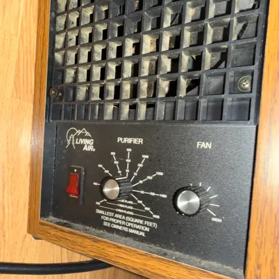 Sale Photo Thumbnail #22: Vintage Living Air tabletop air purifier with a woodgrain cabinet, black front grille, and manual control dials.
