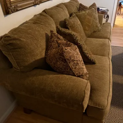 Sale Photo Thumbnail #78: Traditional olive green chenille or textured fabric sofa accompanied by patterned throw pillows with fringe trim.
