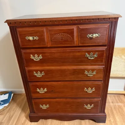 Sale Photo Thumbnail #128: Traditional cherry highboy chest of drawers featuring brass bail handles, a carved fan motif on the top center drawer, and a dentil molded top edge.