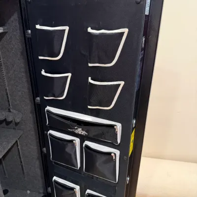 Sale Photo Thumbnail #370: Open heavy-duty gun safe door fitted with a fabric door organizer panel featuring multiple storage pouches and zippered pockets.