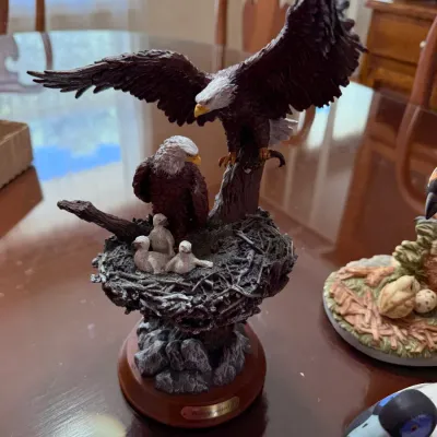 Sale Photo Thumbnail #252: Detailed resin eagle family figurine, featuring two adult bald eagles and eaglets in a nest, mounted on a wooden display base.