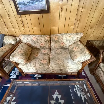 Sale Photo Thumbnail #400: Vintage bamboo and rattan sofa seating set with tropical floral upholstery, accompanied by a matching glass-top coffee table.