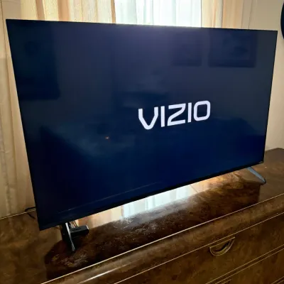 Sale Photo Thumbnail #99: Vizio flat-screen television resting on a burl wood dresser with brass hardware.