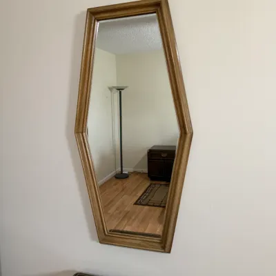 Sale Photo Thumbnail #104: Vintage hexagonal wood-framed wall mirror, likely mid-to-late 20th century.
