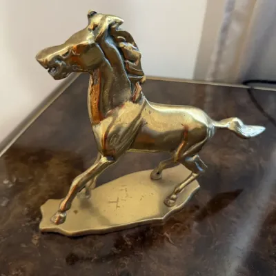 Sale Photo Thumbnail #360: Vintage solid brass rearing horse figurine mounted on an integral brass base, featuring a polished finish with minor age patina.