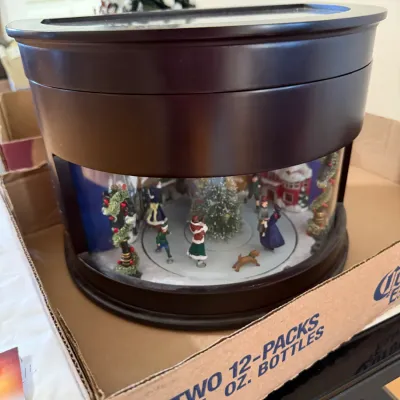 Sale Photo Thumbnail #352: Vintage Mr. Christmas animated musical ice skating display in a dark wood half-moon cabinet.