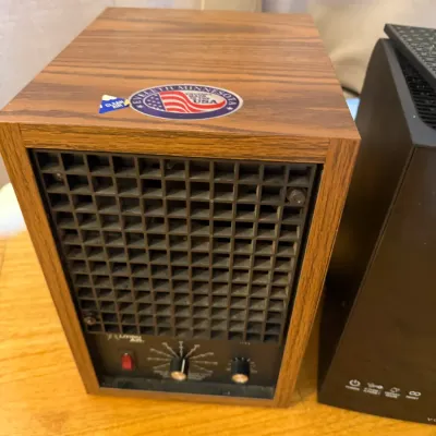 Sale Photo Thumbnail #181: Vintage Living Air woodgrain air purifier unit featuring a front eggcrate grille and analog control knobs.
