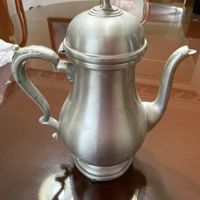 Sale Photo Thumbnail #202: Vintage pewter teapot or coffee pot featuring a domed hinged lid with a finial and an ornate curved handle.