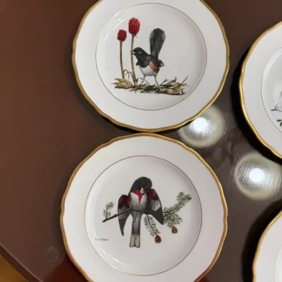 Sale Photo Thumbnail #205: Set of vintage porcelain bird plates featuring illustrations by Ray Harm with gold-trimmed scalloped rims.