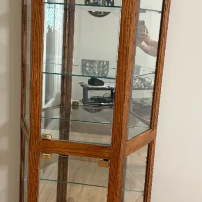 Sale Photo Thumbnail #19: Tall octagonal oak curio display cabinet featuring glass doors, mirrored interior back, and adjustable glass shelves.
