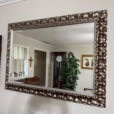 Sale Photo Thumbnail #49: Large rectangular wall mirror with a heavy silver-toned ornate carved frame, reflecting a home interior.