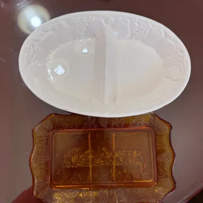 Sale Photo Thumbnail #194: Vintage milk glass divided serving dish with embossed fruit motif, alongside an amber glass rectangular dish featuring a Last Supper scene.