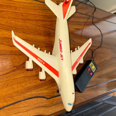 Sale Photo Thumbnail #322: Vintage plastic battery-operated 'Jumbo Jet' toy airplane with tethered remote controller.