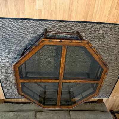 Sale Photo Thumbnail #320: Vintage octagonal wooden coffee table featuring glass panel inserts and faux bamboo carved details, shown from an overhead view resting on a geometric area rug.