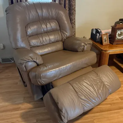Sale Photo Thumbnail #87: Taupe leather power lift recliner chair featuring a channeled backrest and padded armrests, shown in a partially reclined position.