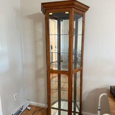 Sale Photo Thumbnail #156: Tall octagonal oak curio cabinet with interior glass shelves, mirrored back, and integrated lighting.