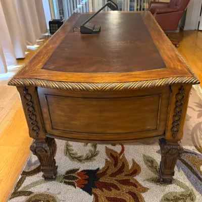 Sale Photo Thumbnail #56: Traditional wooden executive desk featuring a brown leather inset top, carved rope-edge detailing, decorative side accents, and ornate carved legs.