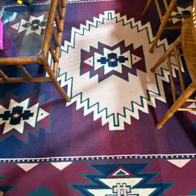 Sale Photo Thumbnail #410: Large Southwestern style area rug featuring a geometric motif in shades of purple, teal, cream, and maroon.
