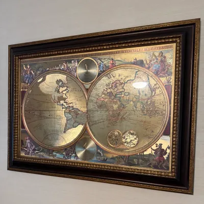 Sale Photo Thumbnail #89: Framed vintage-style metallic foil world map print featuring dual hemispheres, intricate illustrations, and a dark wood frame.