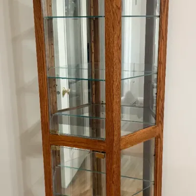 Sale Photo Thumbnail #18: Tall, hexagon-shaped oak display cabinet with glass panels, glass shelves, and a mirrored back.