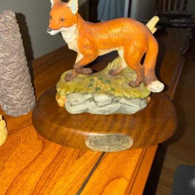 Sale Photo Thumbnail #276: Painted porcelain red fox figurine mounted on a finished wooden base with a brass nameplate.