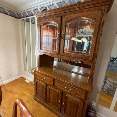 Sale Photo Thumbnail #191: Traditional oak china hutch with leaded glass cabinet doors, brass hardware, and a mirrored back display shelf.