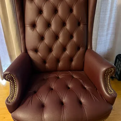 Sale Photo Thumbnail #67: Burgundy leather Chesterfield-style high-back executive desk chair featuring deep button tufting and brass nailhead trim on a rolling base.