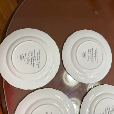 Sale Photo Thumbnail #216: Undersides of four Spode bone china collector plates from the American Songbird Series featuring artwork by Ray Harm.