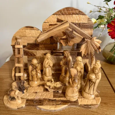 Sale Photo Thumbnail #159: Hand-carved olive wood nativity set featuring a stable background with figurines, showcasing rich natural wood grain.