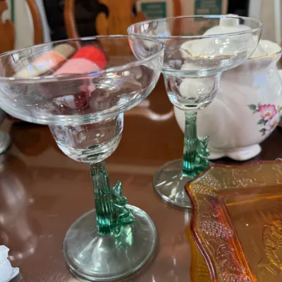 Sale Photo Thumbnail #198: Pair of margarita glasses featuring green cactus-shaped stems and clear glass bowls.