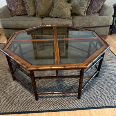 Sale Photo Thumbnail #318: Octagonal faux-bamboo coffee table with a glass insert top, positioned over a geometric pattern area rug.