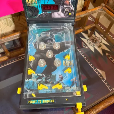Sale Photo Thumbnail #403: Vintage King Kong tabletop arcade pinball game featuring electronic scoring display, light-up header graphics, and yellow flippers.