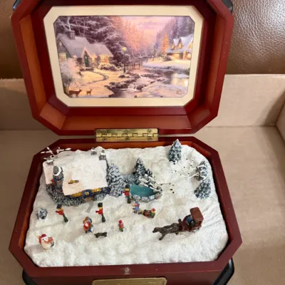 Sale Photo Thumbnail #347: Thomas Kinkade winter village musical jewelry box featuring a 3D snowy landscape inside and a framed print under the lid.