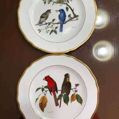 Sale Photo Thumbnail #207: Pair of vintage porcelain collector plates featuring artwork of songbirds with scalloped gold rims, signed Ray Harm.