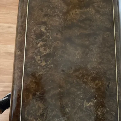 Sale Photo Thumbnail #107: Top surface of a vintage burl wood side table featuring inlaid brass stringing and brass corner accents.