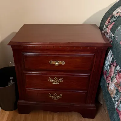 Sale Photo Thumbnail #112: Traditional cherry-finished wooden nightstand featuring three drawers with brass bail pulls and a bracket base.