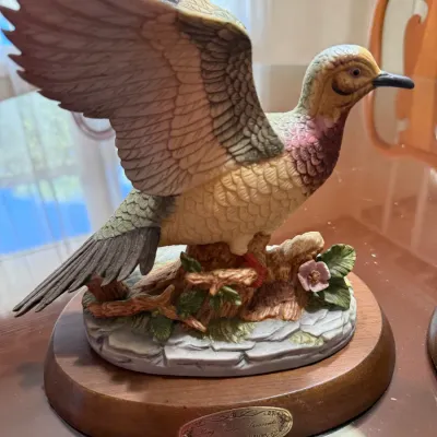Sale Photo Thumbnail #236: Hand-painted ceramic or resin pheasant figurine with wings outstretched, mounted on a naturalistic base and oval wooden display plaque with a brass nameplate.