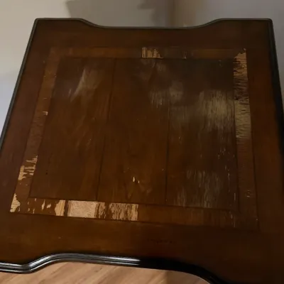 Sale Photo Thumbnail #13: Dark wood end table or side table with inlay detailing, showing significant surface finish wear and peeling along the top.