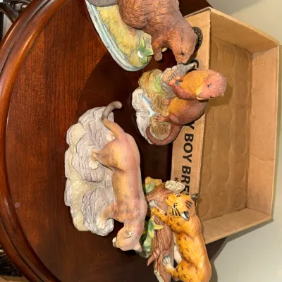 Sale Photo Thumbnail #288: Collection of four vintage painted resin wildlife figurines, including a beaver, otter, cougar, and wildcat depicted on naturalistic stone and wood bases.