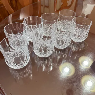 Sale Photo Thumbnail #307: Set of eight clear cut crystal lowball glasses featuring a diamond texture pattern around the bases, arranged on a glossy wooden table.