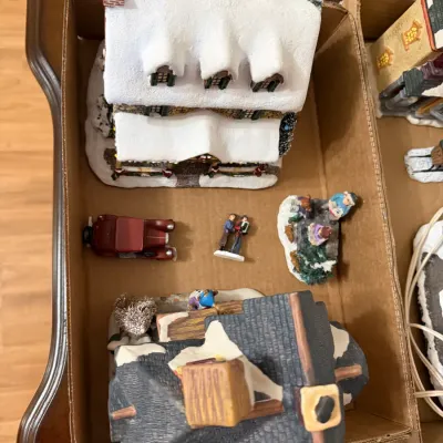 Sale Photo Thumbnail #355: Collection of Christmas village miniature buildings and figurines, packed in a cardboard box.