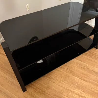 Sale Photo Thumbnail #31: Modern black glass three-shelf TV stand or media console with a sleek, minimalist frame.