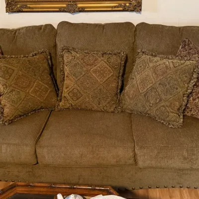 Sale Photo Thumbnail #77: Traditional olive green upholstered three-cushion sofa with nailhead trim detailing and five coordinating accent pillows.