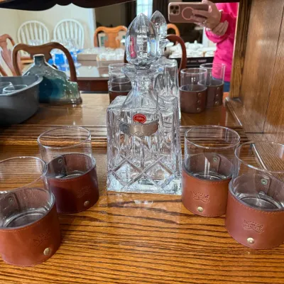 Sale Photo Thumbnail #334: Vintage cut crystal decanter with stopper and hanging tag, surrounded by four rocks glasses with stitched leather wraps.