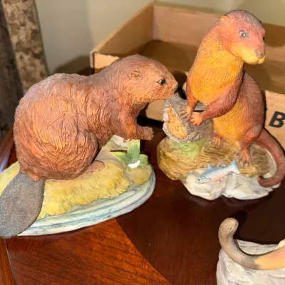 Sale Photo Thumbnail #289: Pair of resin wildlife figurines featuring a beaver and an otter on scenic base displays, both in good condition with detailed fur texturing.