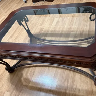 Sale Photo Thumbnail #27: Octagonal wood and glass coffee table featuring carved trim and dark metal scrollwork legs.