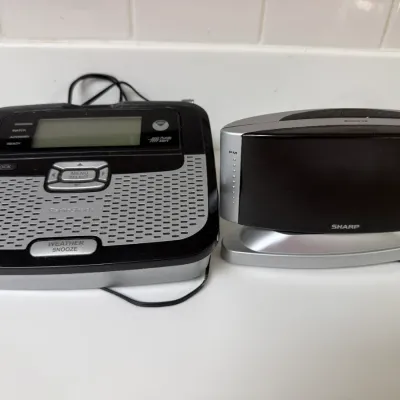 Sale Photo Thumbnail #152: RadioShack public alert weather radio alongside a modern Sharp digital alarm clock.