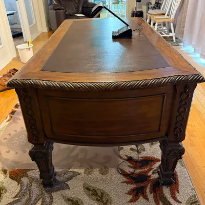 Sale Photo Thumbnail #57: Traditional executive desk featuring a faux-leather inlay top, rope-twist trim, and carved leg detailing, topped with a black modern desk lamp.