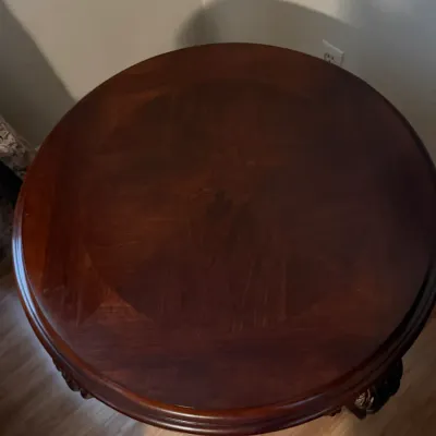 Sale Photo Thumbnail #82: Round dark mahogany side table featuring a starburst wood grain veneer top and carved detail accents.